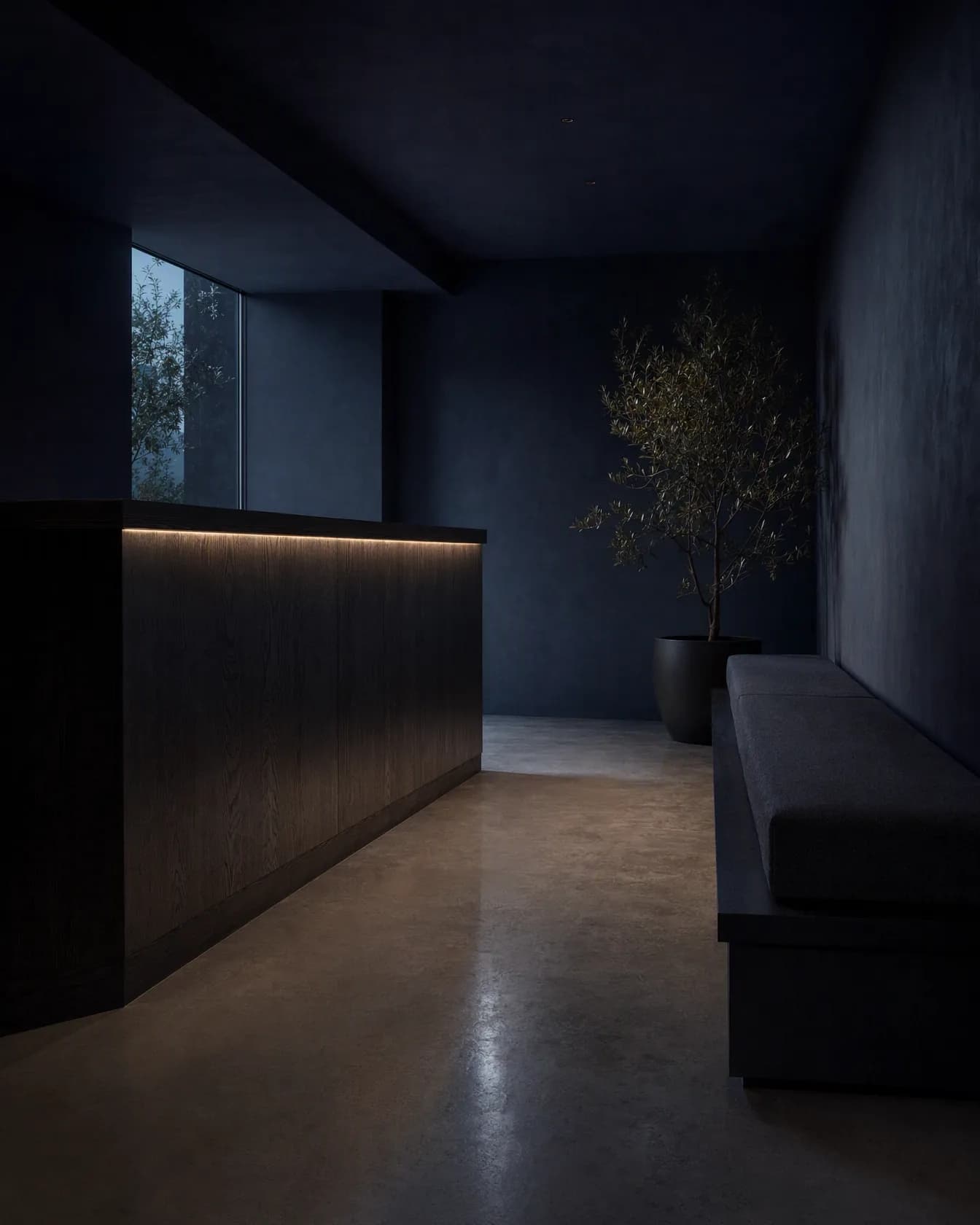 A clinic reception desk in oak and pale stone with two armchairs beside a window